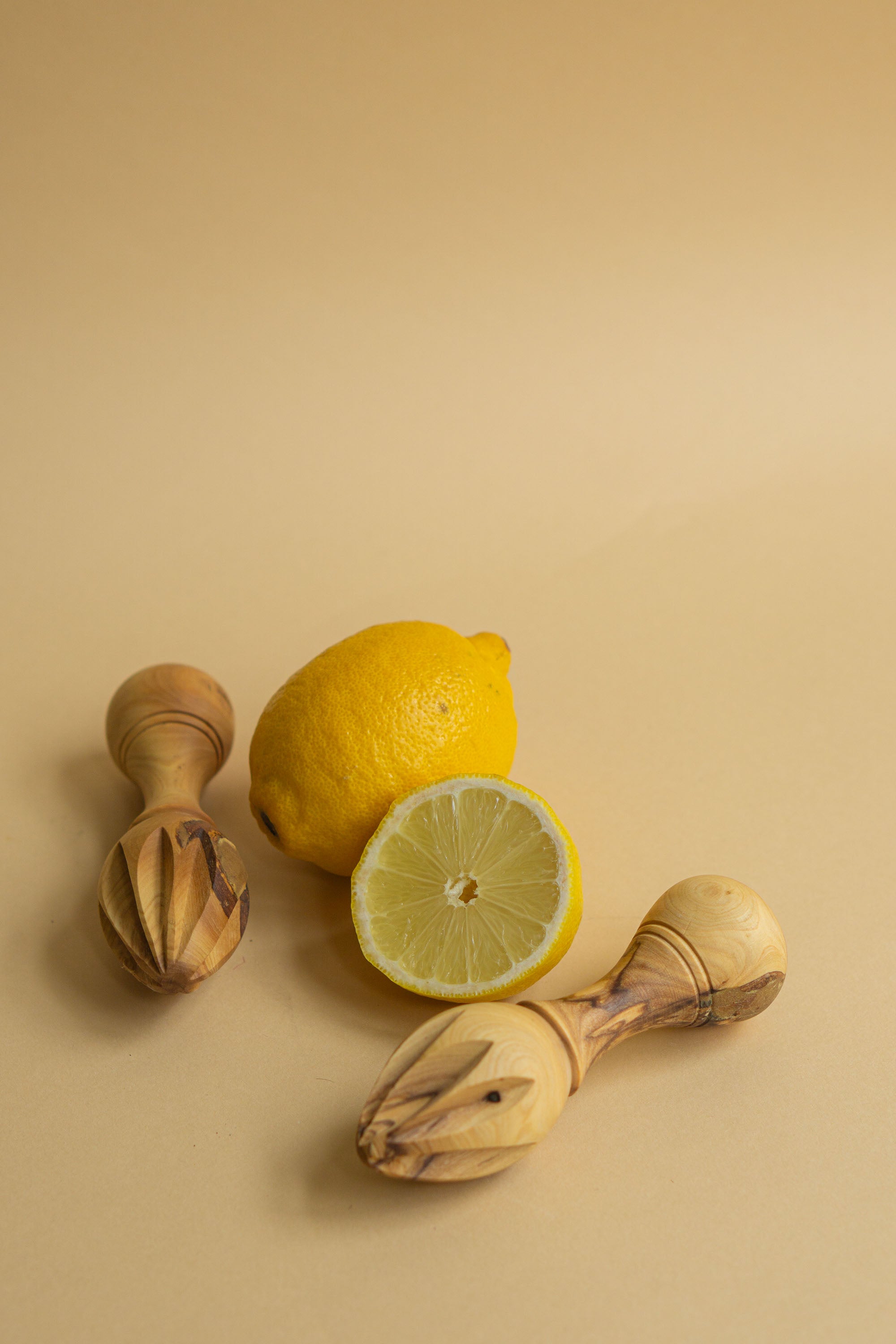 Håndlavet citruspresser i oliventræ med citron som baggrund. Perfekt til at presse saft fra citrusfrugter.