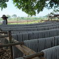 Kvindelig væver fra Myanmar arbejder på en backstrap væv med en 2 meter lang bordløber